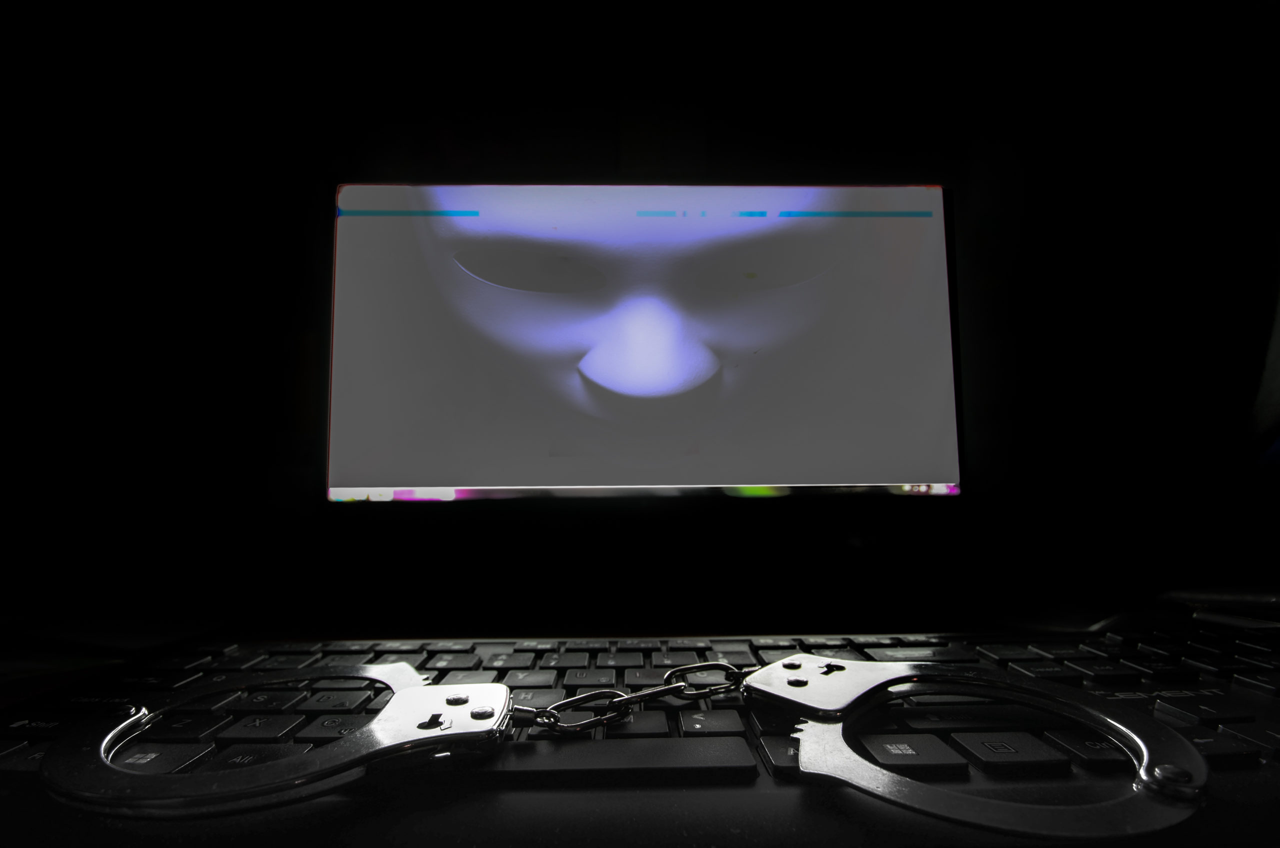 screen and handcuffs on a computers keyboard